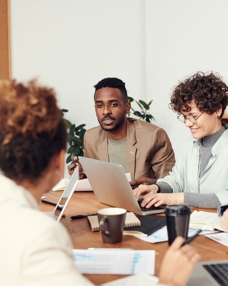 EXPORTAS — professional team meeting with laptops and compliance documents in modern office